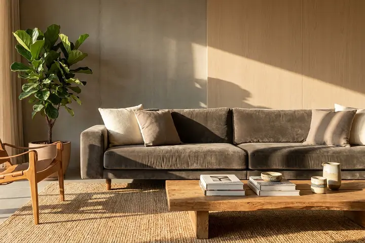 Sofá em veludo escuro numa sala moderna com luz natural