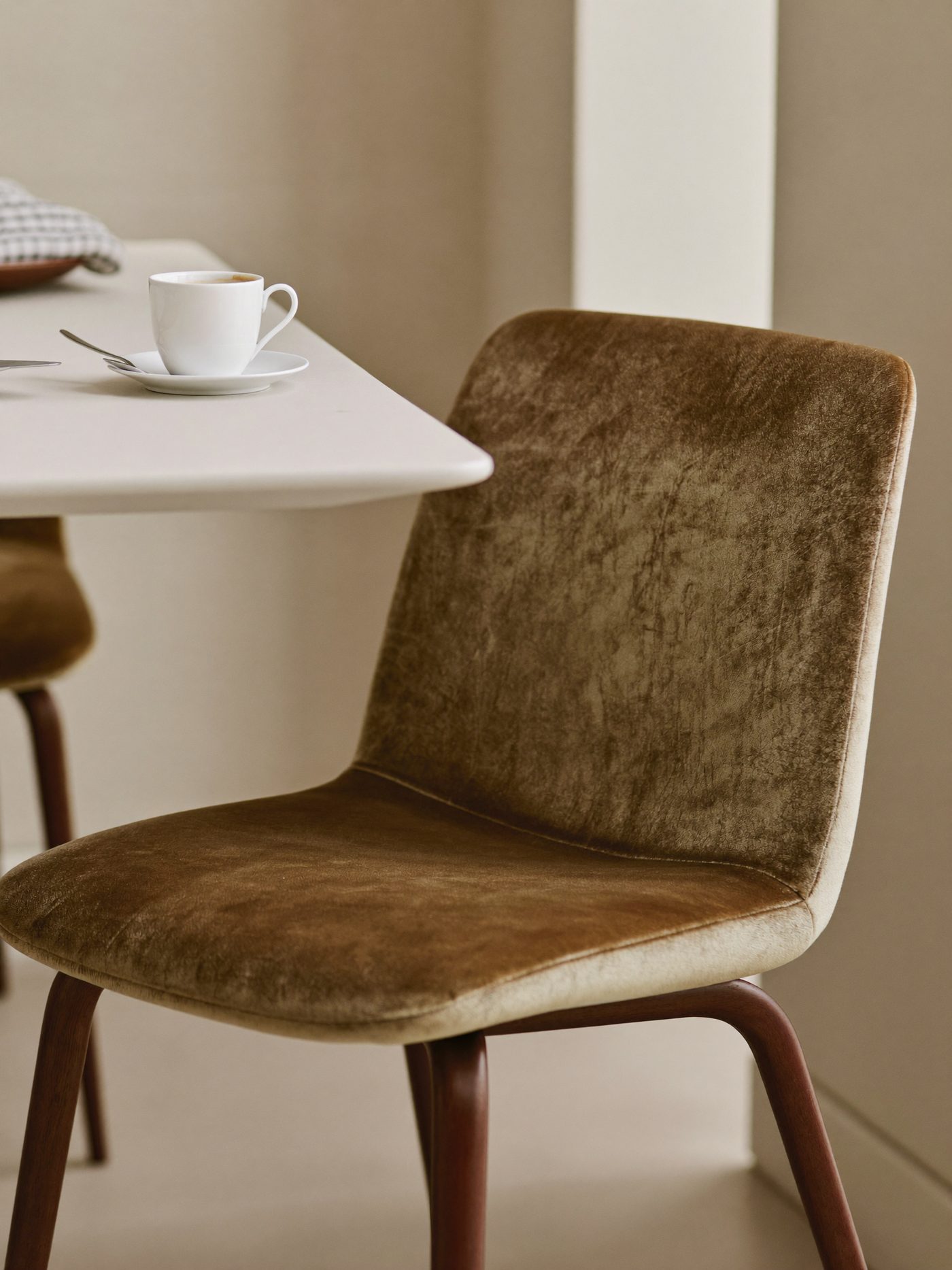 Cadeira de jantar em veludo Milano com xícara de café sobre a mesa