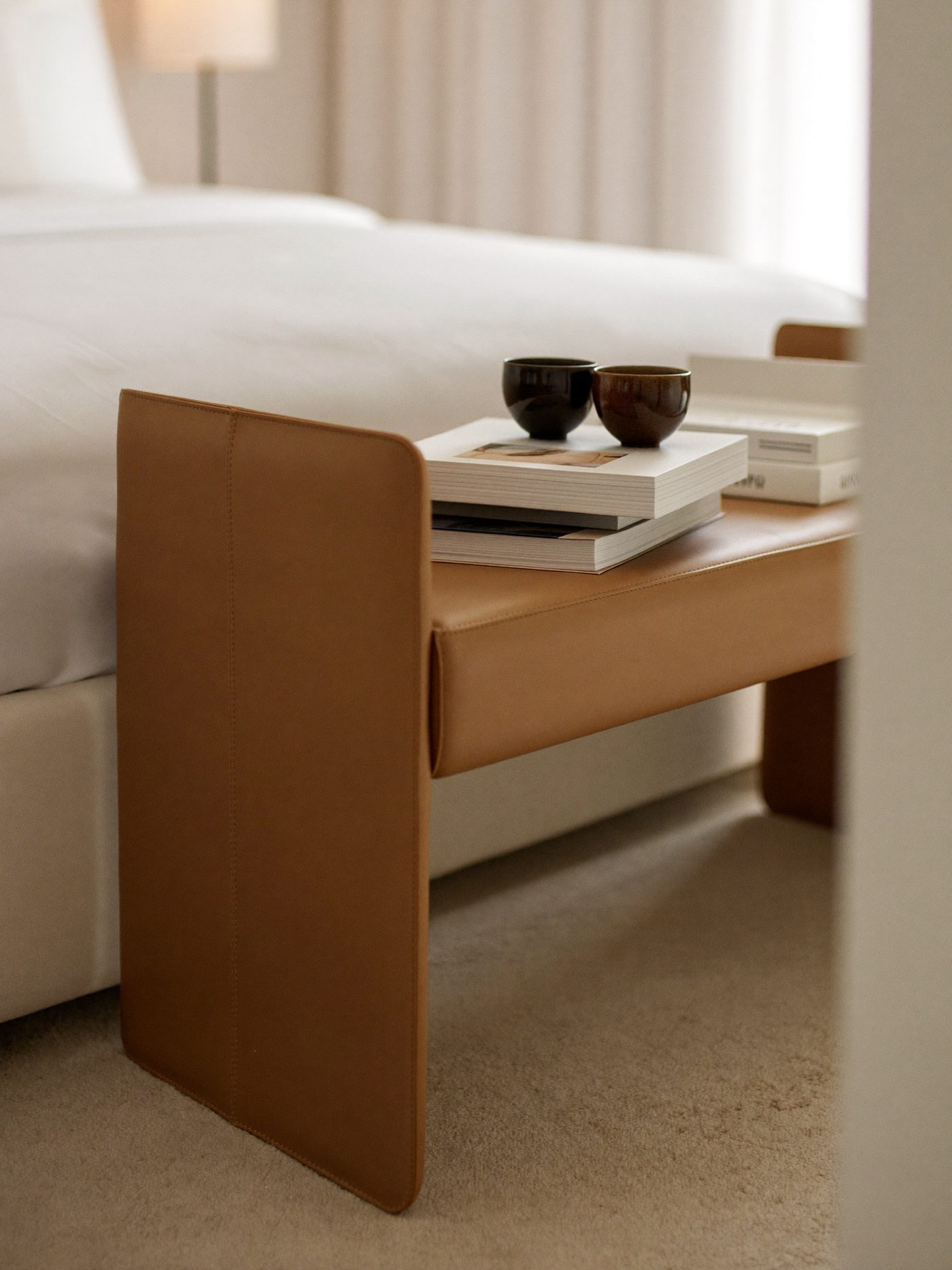 Banco aos pés da cama estofado em napa em quarto minimalista