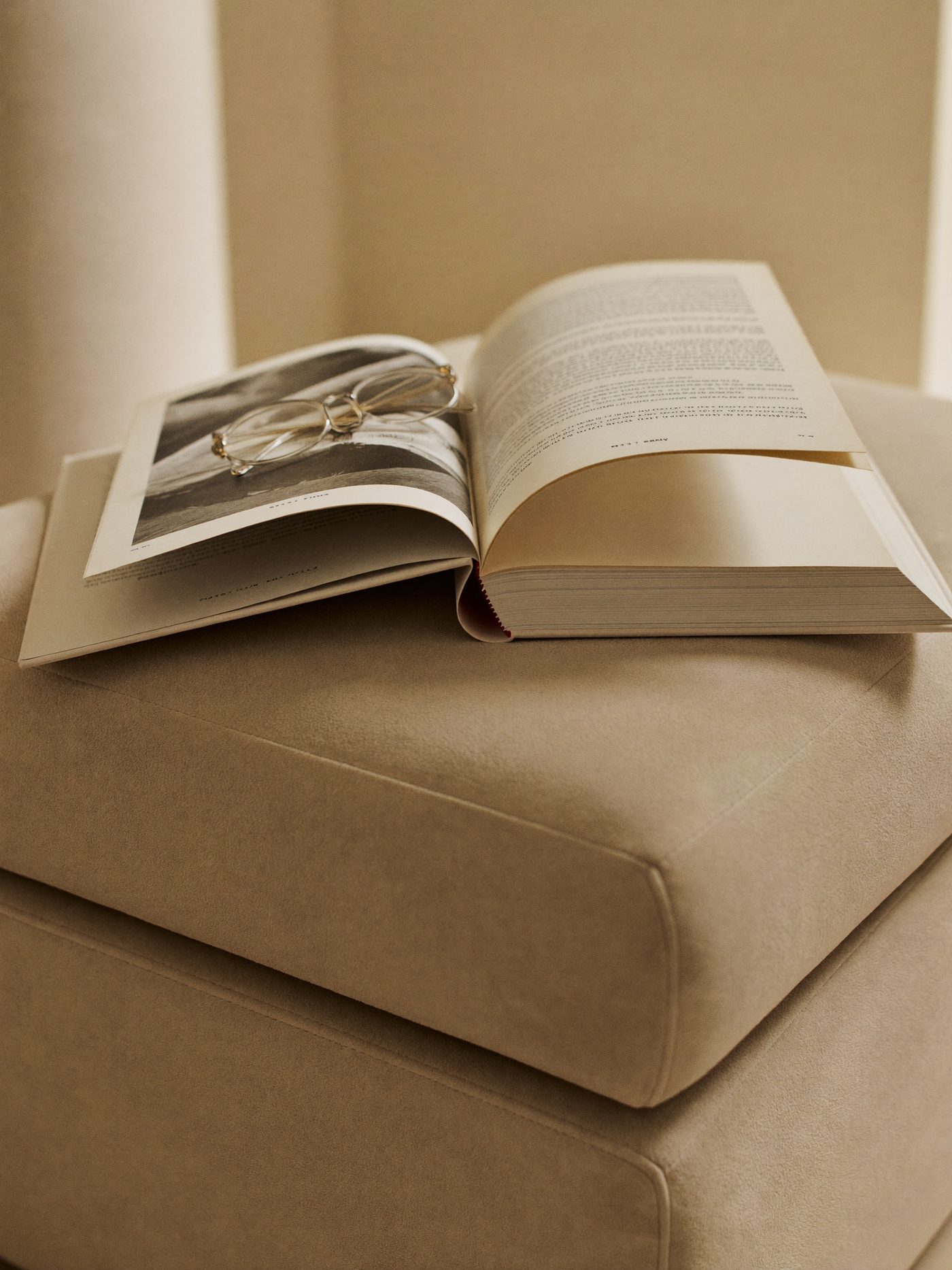 Pufe em suede Nebraska com livro e óculos de leitura